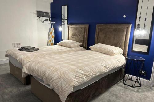 2 camas en un dormitorio con una pared azul en House - Sleeps 5 - Garden - Parking, en Bridgend