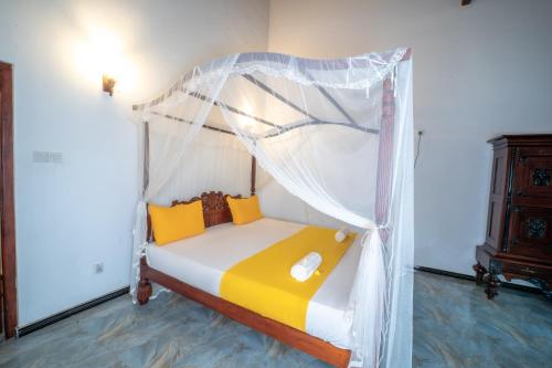 a bed with a canopy in a room at Araliya Gardens Hotel in Hikkaduwa
