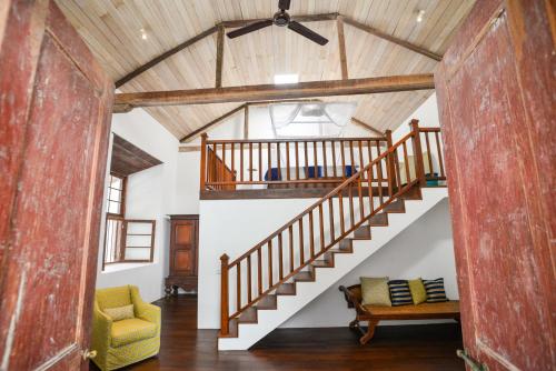 a living room with a staircase and a yellow chair at 32 Middle Street - 03 Bedrooms villa with private pool in Galle