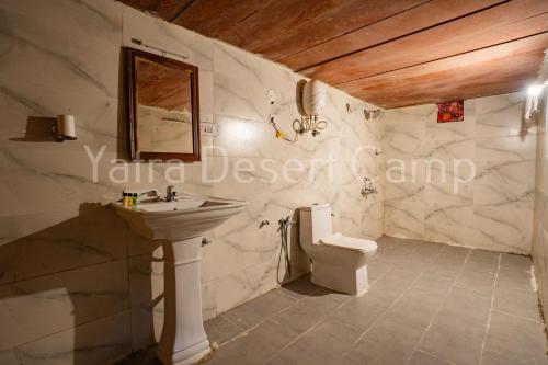 a bathroom with a sink and a toilet at Yatra Desert Resort in Jaisalmer