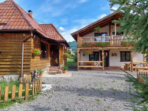 a wooden house with a fence next to it at Cabana Mareea -Lunca Bradului in Lunca Bradului