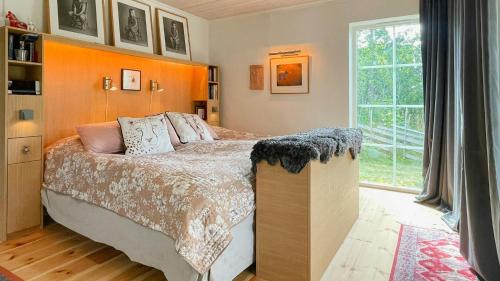 ein Schlafzimmer mit einem Bett und einem großen Fenster in der Unterkunft Stone House With Sea View In Katthammarsvik in Katthammarsvik