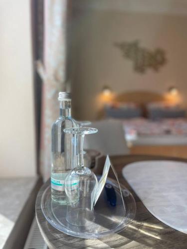 a bottle of water on a glass tray on a table at Hotel Deichvoigt in Cuxhaven