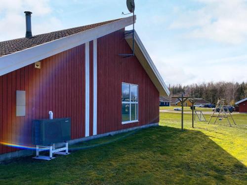 a red building with a window next to a playground at 4 star holiday home in Nordborg in Nordborg