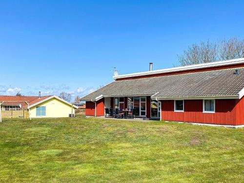 a red house with a lawn in front of it at 4 star holiday home in Nordborg in Nordborg
