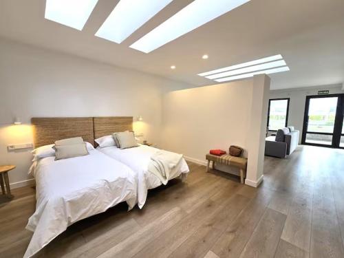 ein Schlafzimmer mit einem großen weißen Bett und einer Couch in der Unterkunft Playa Sardinero Little Homes 3 in Santander