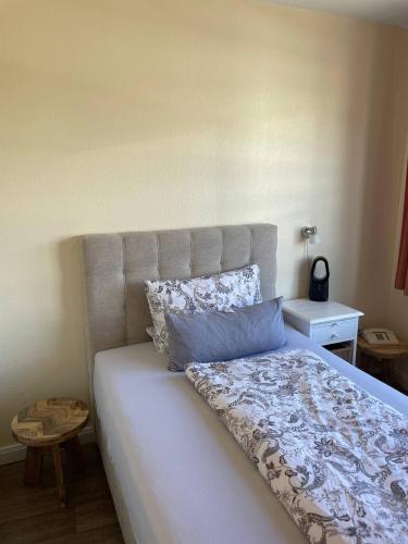 a bedroom with a large white bed with blue pillows at Hotel Deichvoigt in Cuxhaven