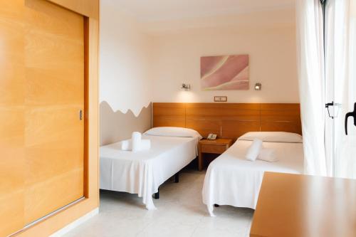 two beds with white sheets in a room at Moon Dreams Atlantic in Es Cana