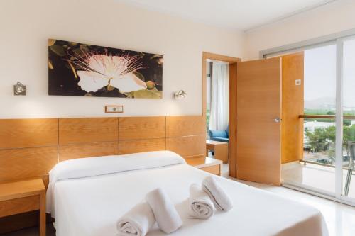 a bedroom with two white beds and a large window at Moon Dreams Atlantic in Es Cana