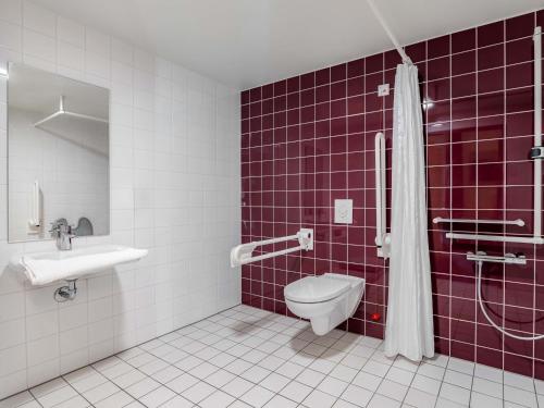 a bathroom with a toilet and a sink at B&B Hotel Stuttgart-Bad Cannstatt in Stuttgart