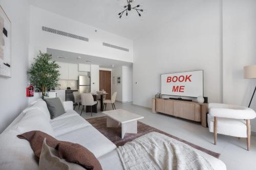 a living room with a white couch and a table at Free housekeeping visits during your stay - StayShort - MJL Apartment for 4 people near Water Parks in Dubai