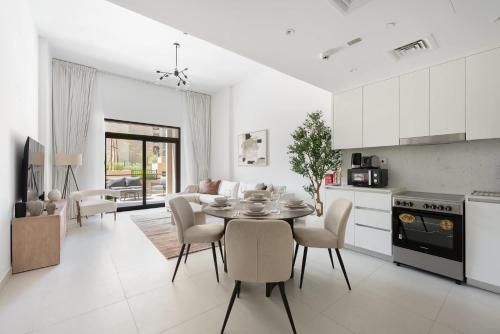 a kitchen and living room with a table and chairs at Free housekeeping visits during your stay - StayShort - MJL Apartment for 4 people near Water Parks in Dubai