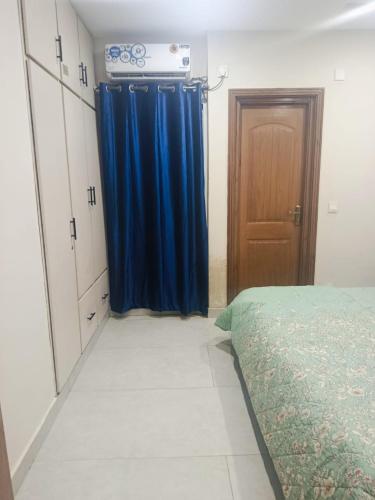 a bedroom with a blue curtain and a bed at Doha emporium FMC, B17 ISLAMABAD in Islamabad