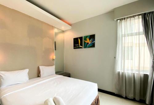 Кровать или кровати в номере Rokumi Luxury Court Condominium