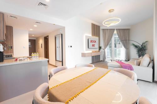 a kitchen and a living room with a table and chairs at Free housekeeping visits during your stay - StayShort - Business Bay for 4 people with City Views in Dubai