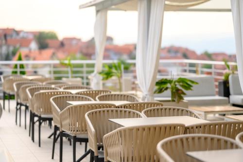 a row of tables and chairs on a balcony at Hotel Tami Residence in Niš