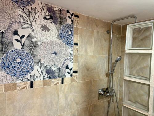 a bathroom with a shower with a floral wallpaper at Torres de la Catedral in Jaén