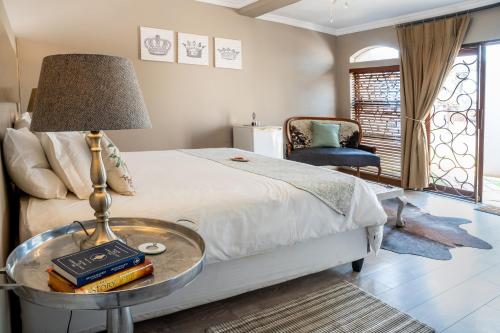 a bedroom with a bed and a table with books at Klip en Kristal Guest House in Bela-Bela