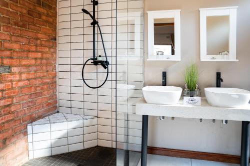 a bathroom with two sinks and a shower at Klip en Kristal Guest House in Bela-Bela