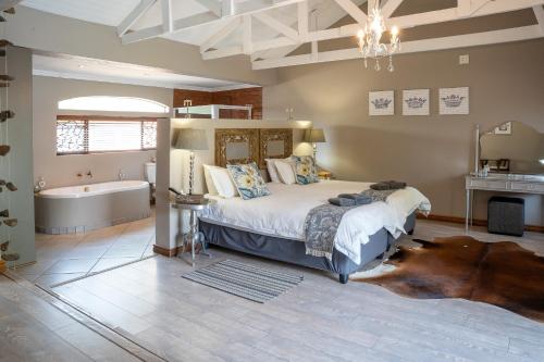 a bedroom with a large bed and a bath tub at Klip en Kristal Guest House in Bela-Bela