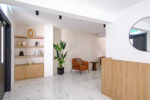 a living room with a chair and a mirror at Artemis 302 - Seaside Stories in Livadhia