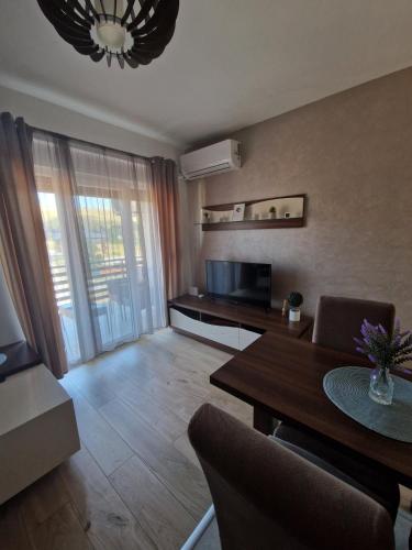 a living room with a dining table and a television at Apartman TEKA in Zlatibor
