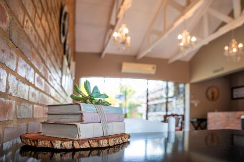 a stack of books sitting on top of a table at Klip en Kristal Guest House in Bela-Bela