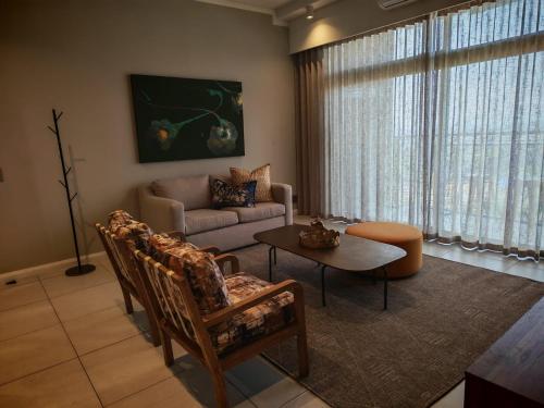 un salon avec un canapé et une table dans l'établissement Menlyn Maine Trilogy Apartment 1316 & 1316A, à Pretoria