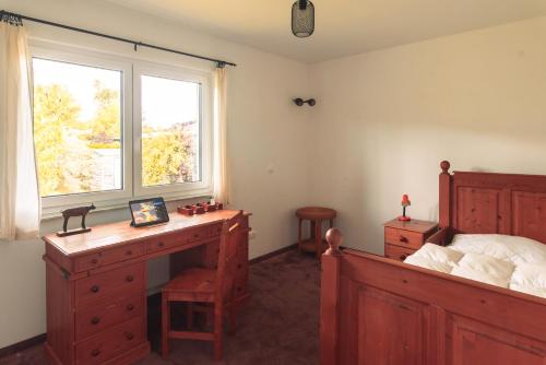 a bedroom with a desk and a bed and a window at Bungalov u řeky a lesa in Planá nad Lužnicí