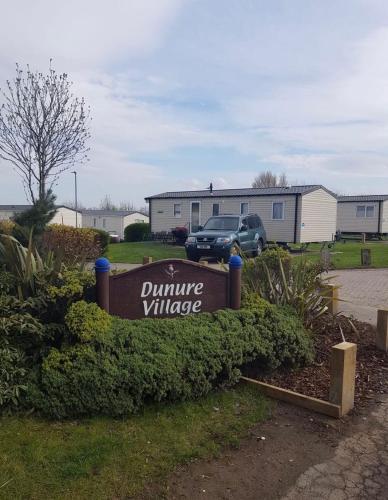 a sign for a university village in a yard at A&L Holiday Home Craigtara in Ayr