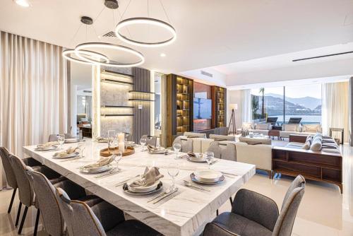 a dining room with a large table and chairs at Luxury Villa 8 BR Sea and Mountain View with infinity pool - Al Dana Island Fujairah in Fujairah