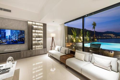 a living room with a white couch and a large window at Luxury Villa 8 BR Sea and Mountain View with infinity pool - Al Dana Island Fujairah in Fujairah