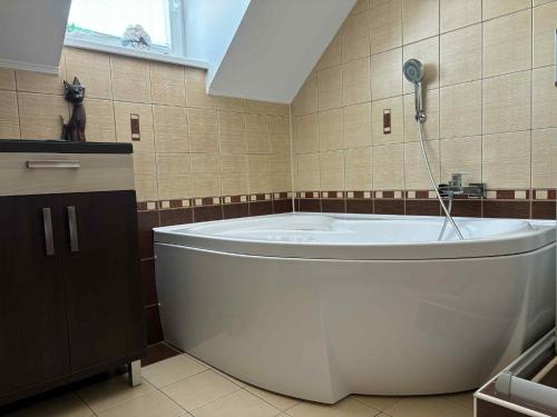 Una gran bañera blanca en un baño con ventana. en Dom pri Veži, en Košice