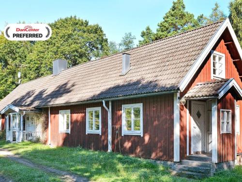 a red house with a gambrel roof at 8 person holiday home in LÖNSBODA-By Traum in Ubbaboda