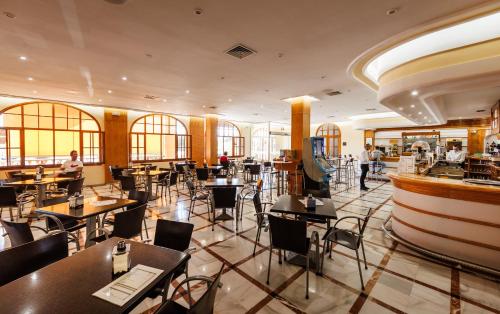 a restaurant with tables and chairs and a wine cellar at Hotel Acosta Vetonia in Almendralejo