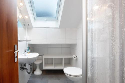 a bathroom with a toilet and a sink and a window at Ferienwohnungen Kehrwieder in Todtnauberg