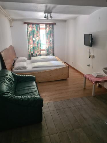a room with a bed and a couch and a window at HOTEL Jerolitsch in Krumpendorf am Wörthersee