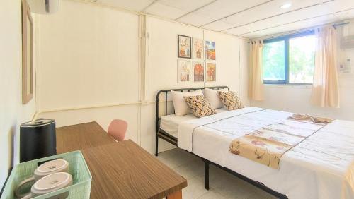 a small bedroom with a bed and a table at Le Panpurie Koh Lanta Resort in Ko Lanta Yai