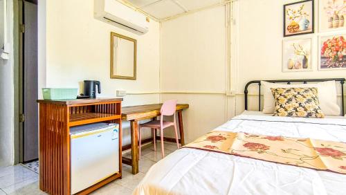 a bedroom with a bed and a desk and a bed sidx sidx sidx at Le Panpurie Koh Lanta Resort in Ko Lanta Yai