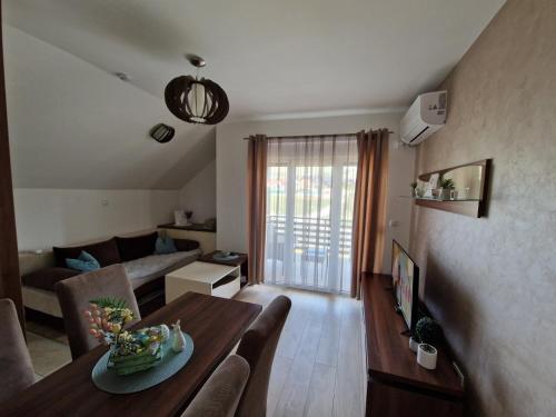 a living room with a table and a couch at Apartman TEKA in Zlatibor