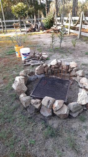 a fire pit with rocks and a grate at Tiny Moor Laguna Garzón in José Ignacio