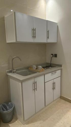 a kitchen with white cabinets and a sink at اضواء السلام للشقق المخدومة in Medina