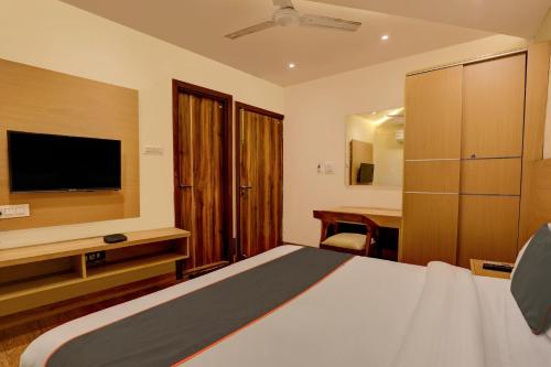 a hotel room with a bed and a television at Collection O Dehradun Central Formerly Hotel Orange Residency in Dehradun