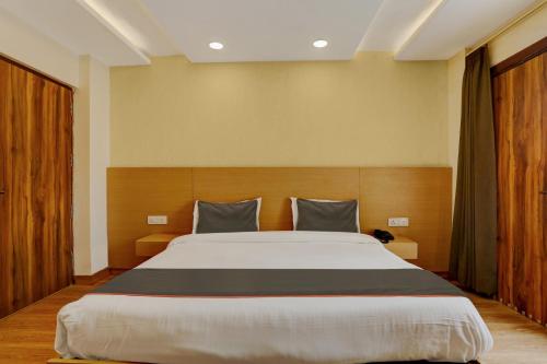 a bedroom with a large bed in a room at Collection O Dehradun Central Formerly Hotel Orange Residency in Dehradun