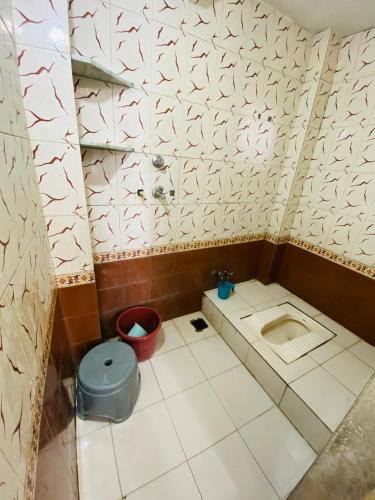 - une petite salle de bains avec des toilettes et un seau dans l'établissement HOTEL SHREE RAM VIJAY Ujjain, à Ujjain