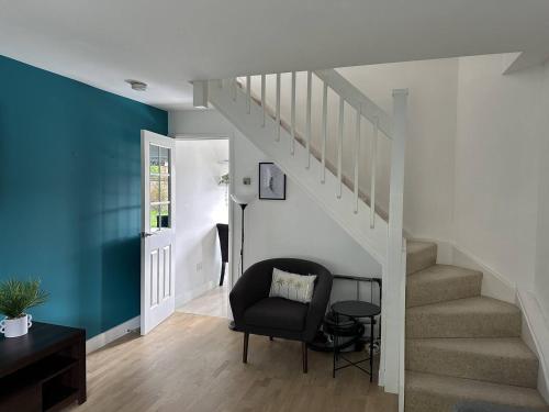 a living room with a chair and stairs at Cosy Home in Churchdown