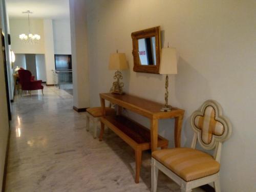 a room with a table and a mirror and a chair at The Enterprise in Karachi