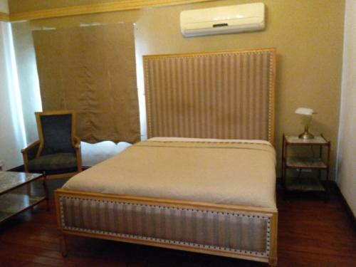 a bedroom with a large bed and a chair at The Enterprise in Karachi