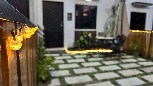a porch with a fence with lights on it at Ellie's Tiny House - Cozy Getaway with Kitchen & Pool Access near SM Dasmariñas in Dasmariñas