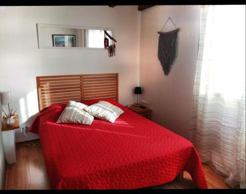 a bedroom with a red bed with a red blanket at Maison mitoyenne 700m de la plage parking privé in Saint-Georges-de-Didonne